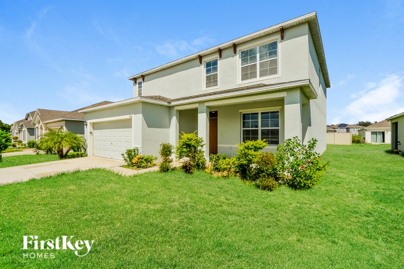 A house with a well-kept lawn and a clear blue sky above.