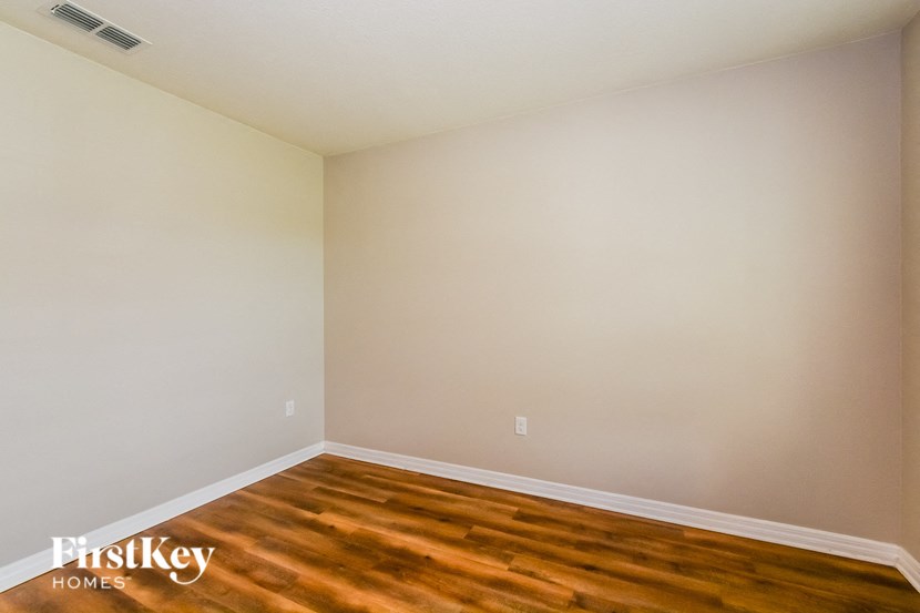 A room with wooden flooring and a FirstKey Homes logo.