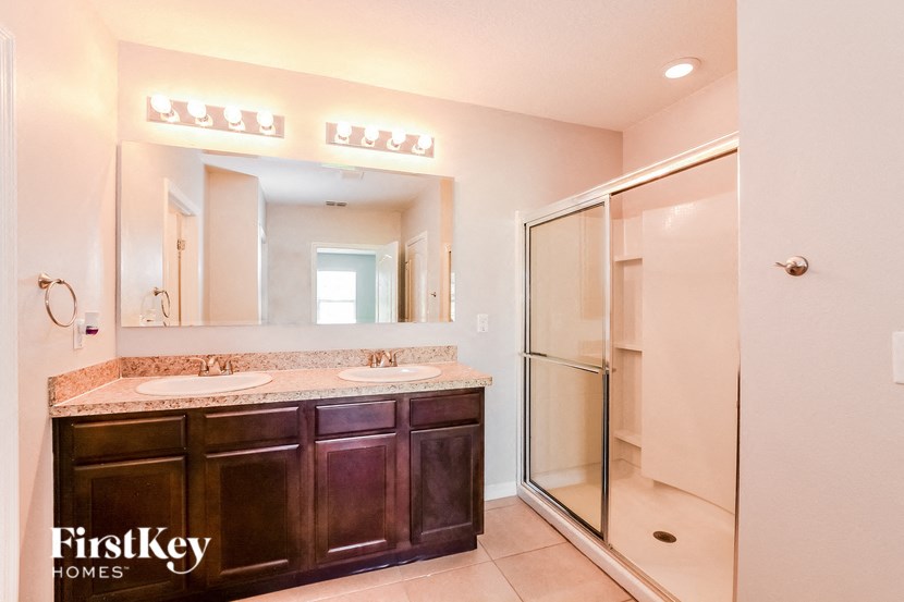 A bathroom with a marble countertop and a walk-in shower.