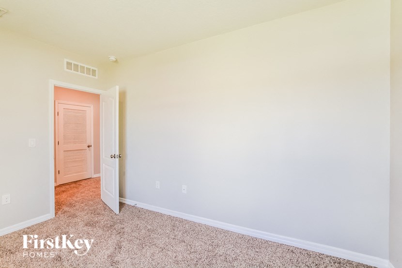 A room with a carpeted floor and a doorway leading to another room.