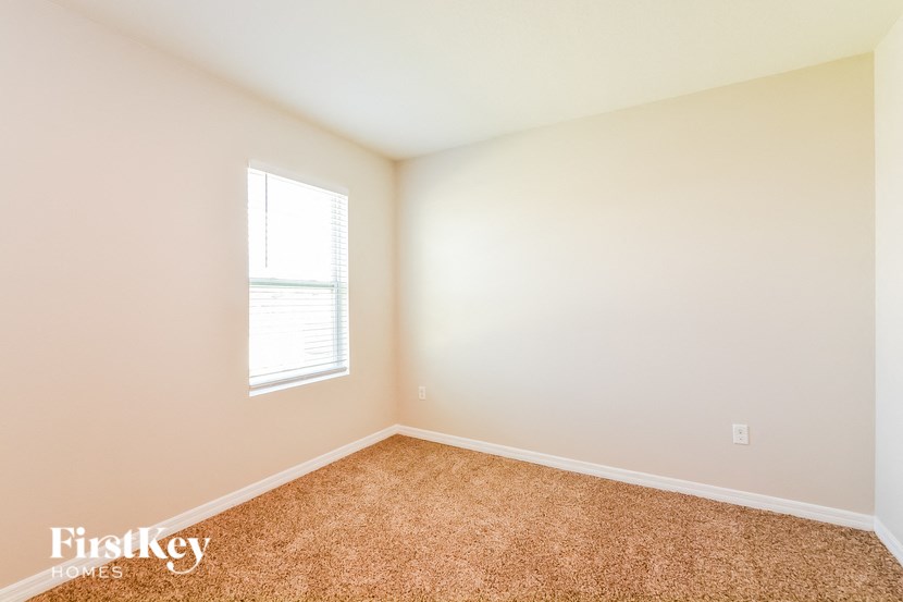 A room with a window and carpeted floor.