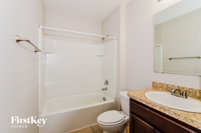A white bathroom with a toilet, sink, and bathtub.