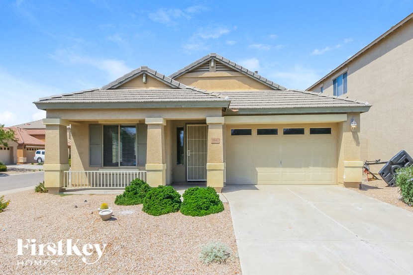 A house with a garage and a driveway in front of it.