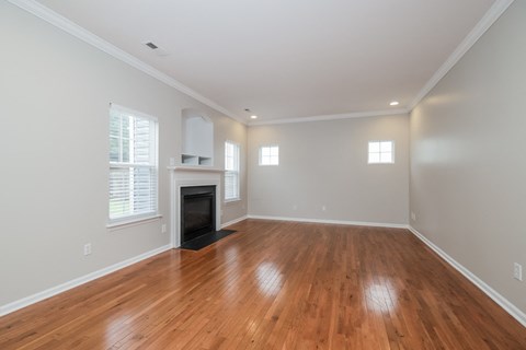 A room with wooden floors and a fireplace.