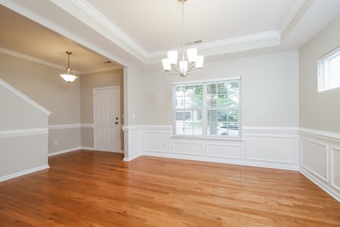 A room with wooden floors and a chandelier.