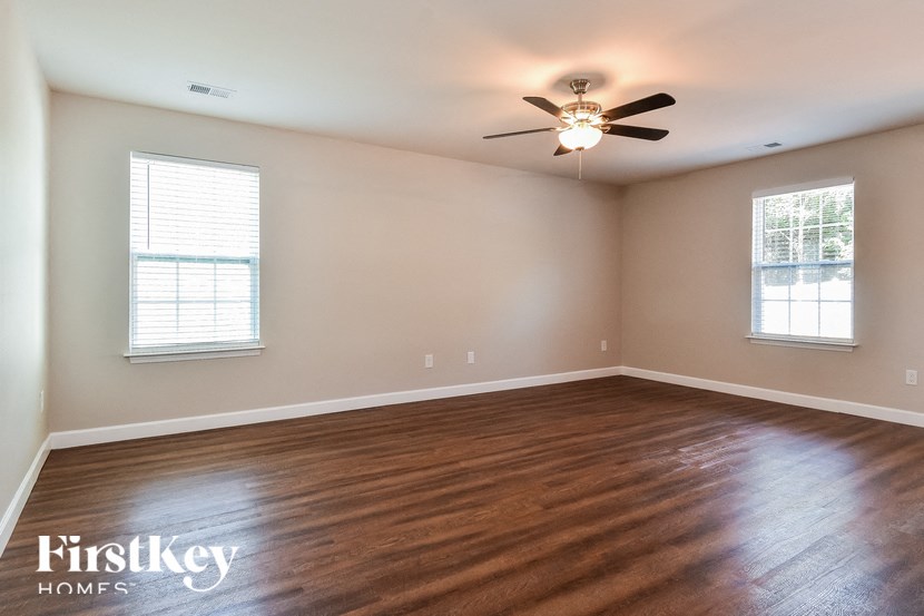 a living room with wood floors and a ceiling fan