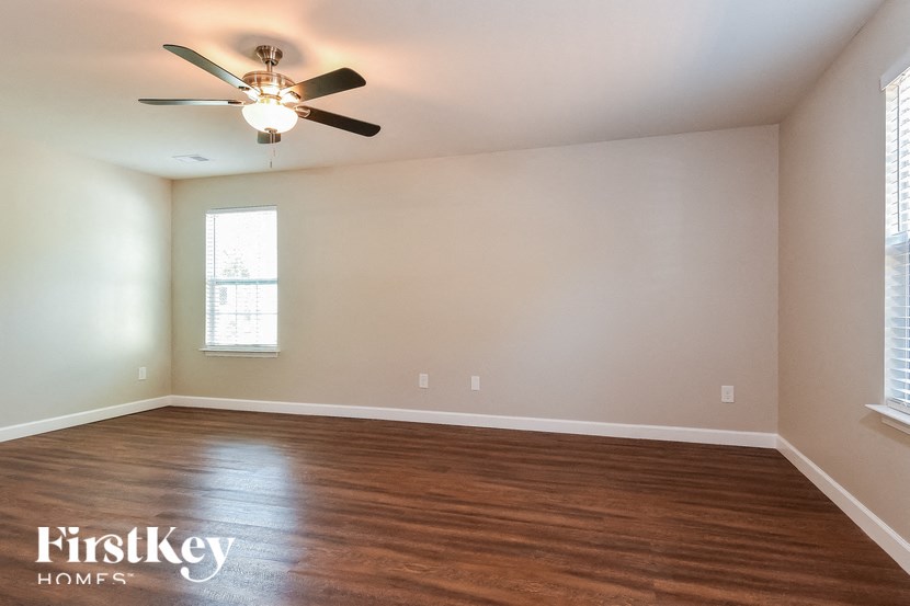 a living room with wood floors and a ceiling fan