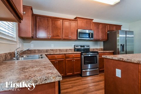 a kitchen with wooden cabinets and granite counter tops and stainless steel appliances
