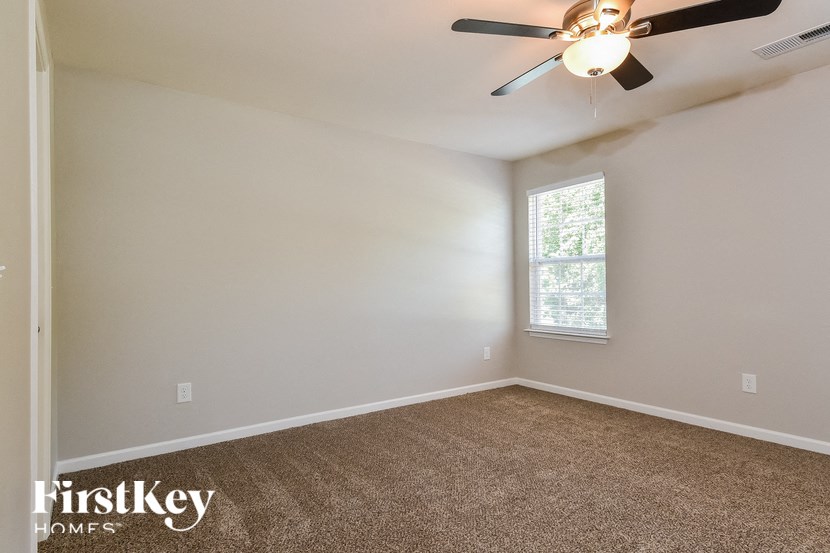 the living room of an empty house with a ceiling fan