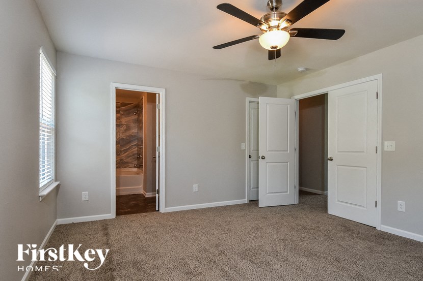 a bedroom with white doors and a ceiling fan