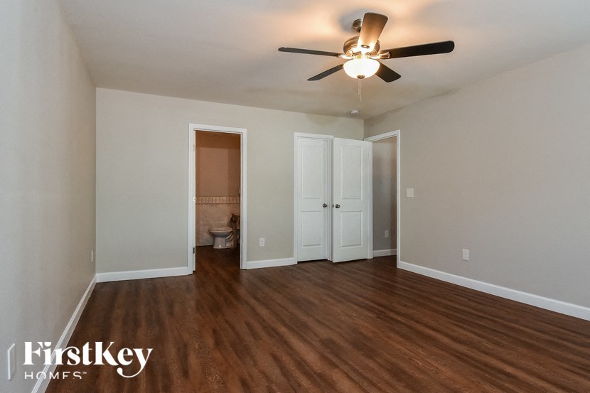 a living room with wood flooring and a ceiling fan