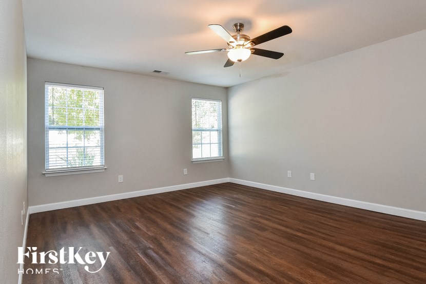 a living room with wood floors and a ceiling fan