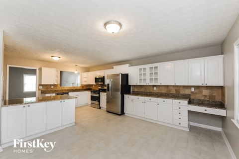 a large kitchen with white cabinets and stainless steel appliances