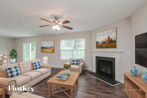 A living room with a fireplace and a painting of a cowboy on the wall.