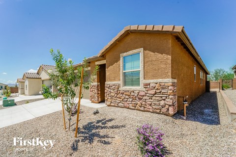 a house with a stone facade and a gravel driveway