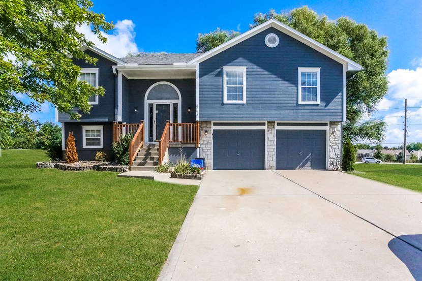 a blue house with a driveway in front of it