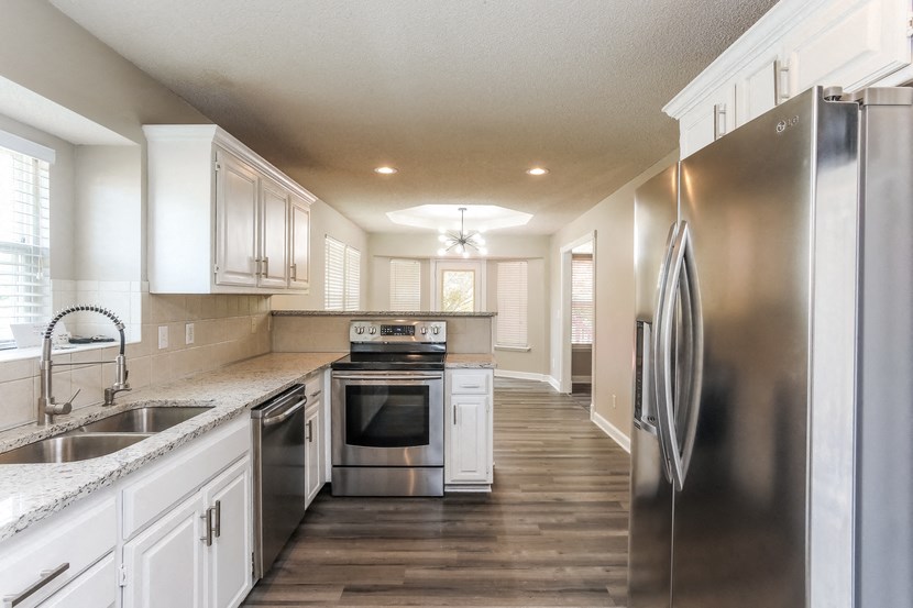a kitchen with stainless steel appliances and white cabinets