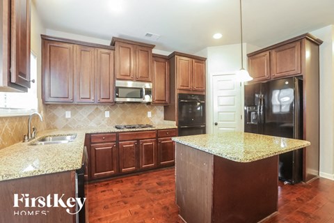 A kitchen with wooden cabinets and a granite countertop.
