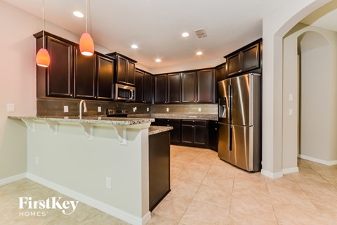 A kitchen with a white counter top and a stainless steel refrigerator.