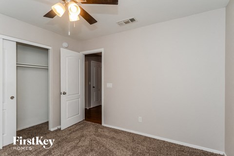 a bedroom with a ceiling fan and a closet