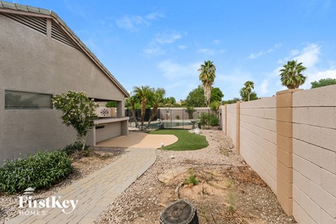 a backyard with a pool and palm trees