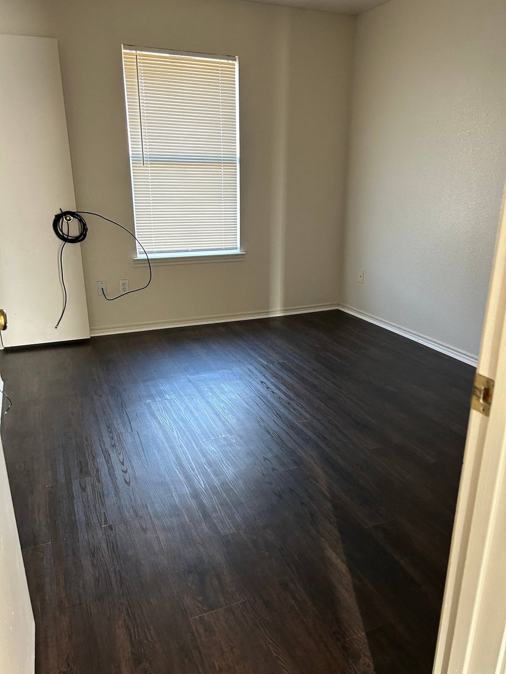 an empty room with wood floors and a window