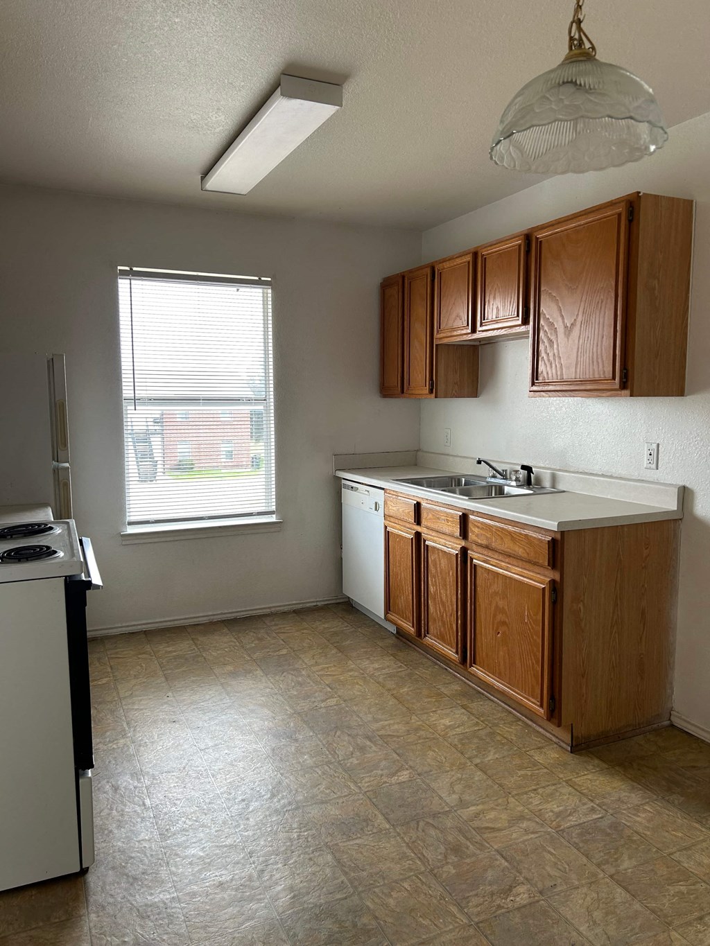 an empty kitchen with wooden cabinets and a sink
