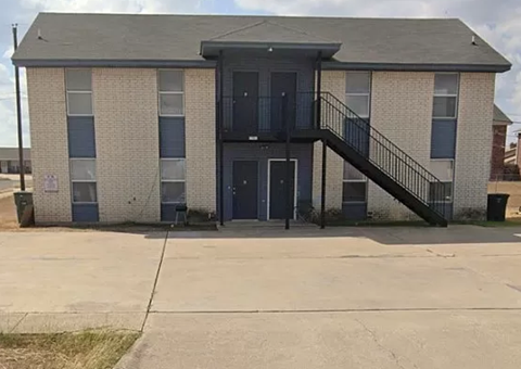 an apartment building with a balcony and a sidewalk