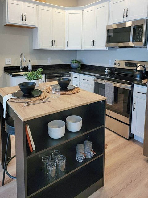 a kitchen with a counter and a stove and a microwave