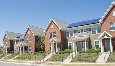 a row of houses with solar panels on the roof