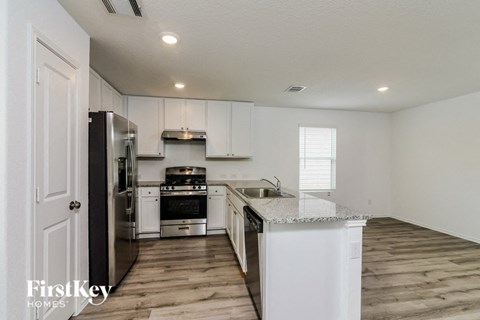 A kitchen with white cabinets and a white fridge.