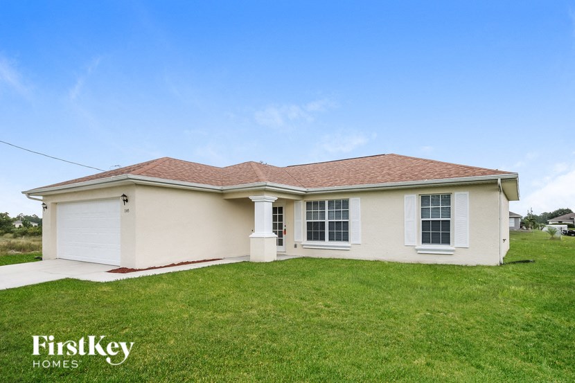 the front view of a white house with a green lawn