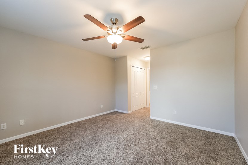 a bedroom with a ceiling fan and a carpeted floor