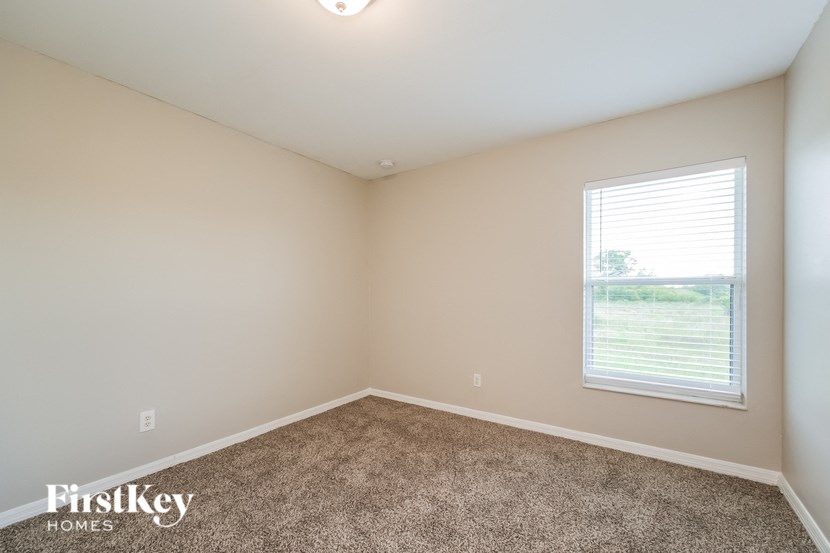 an empty room with carpet and a window