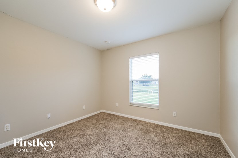 an empty room with carpet and a window