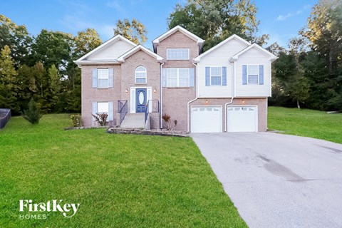 A house with a blue door and a garage is for sale.