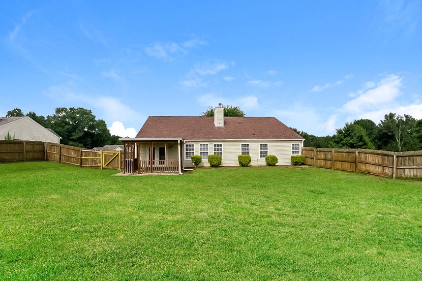a backyard with a fence and a house