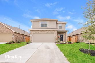 a beige house with a garage and a driveway
