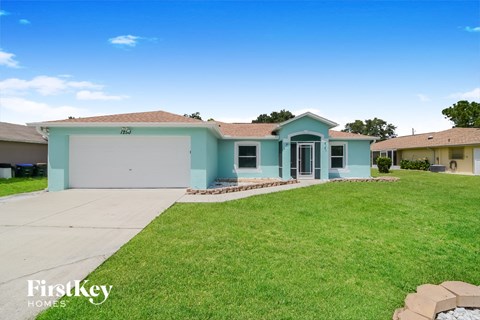 A blue house with a garage is for sale.