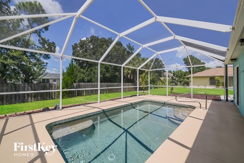 A pool under a white canopy with the words "FirstKey Homes" on the bottom left.