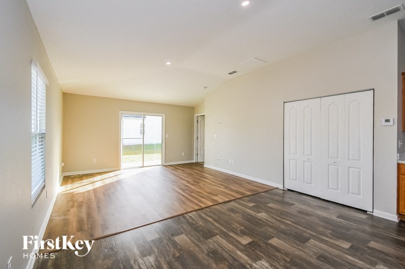 A room with wooden flooring and a sliding glass door.