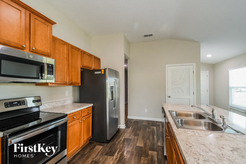 A kitchen with wooden cabinets and a stainless steel refrigerator.