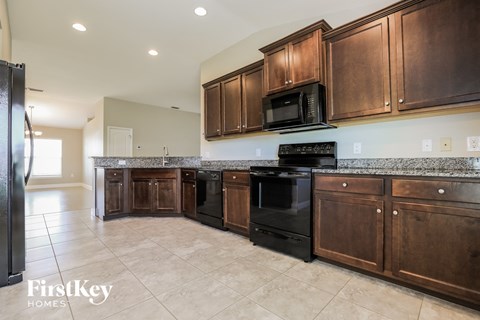 a kitchen with dark wood cabinets and black appliances