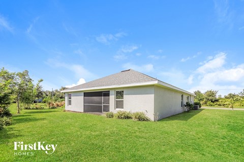 a small house with a grassy yard and a blue sky