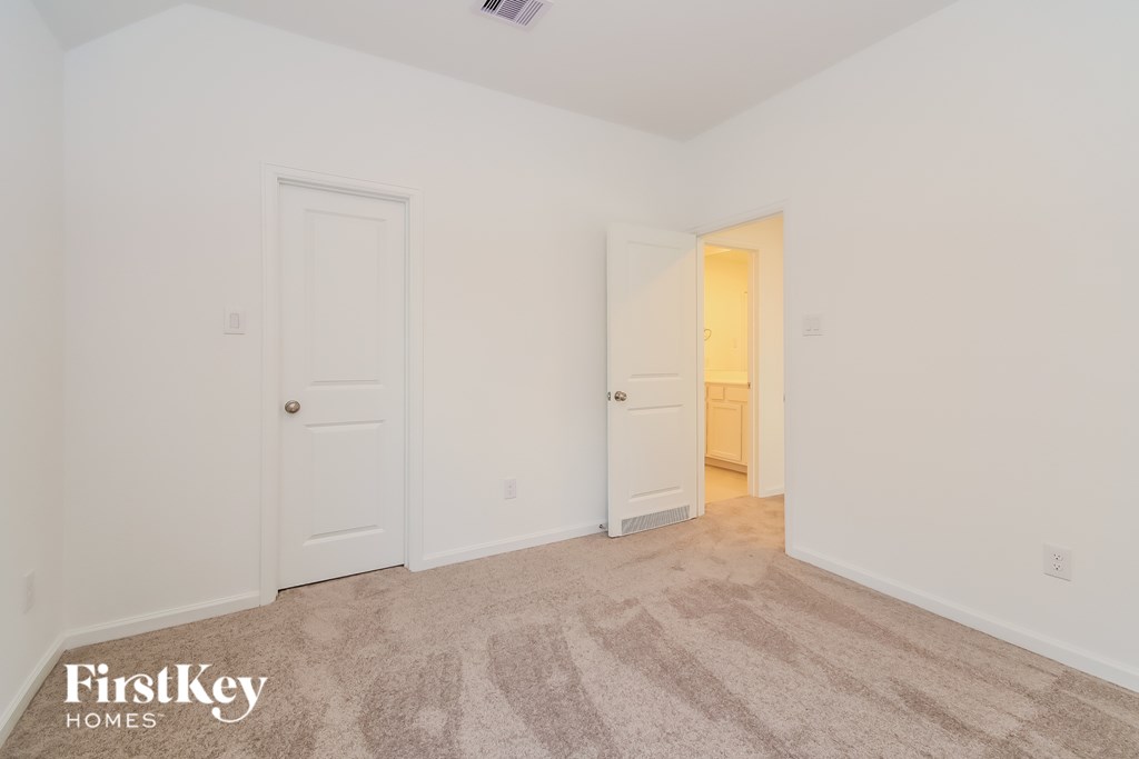 A room with a carpet and two doors.