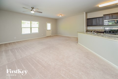 A spacious empty room with a fan and a countertop.