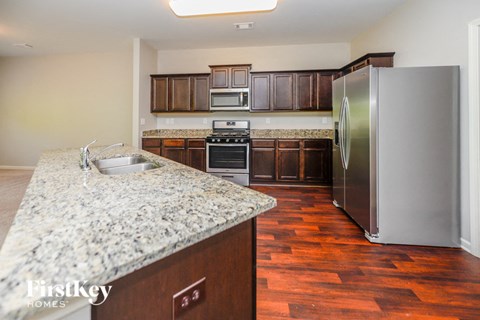A kitchen with a granite counter top and a refrigerator.