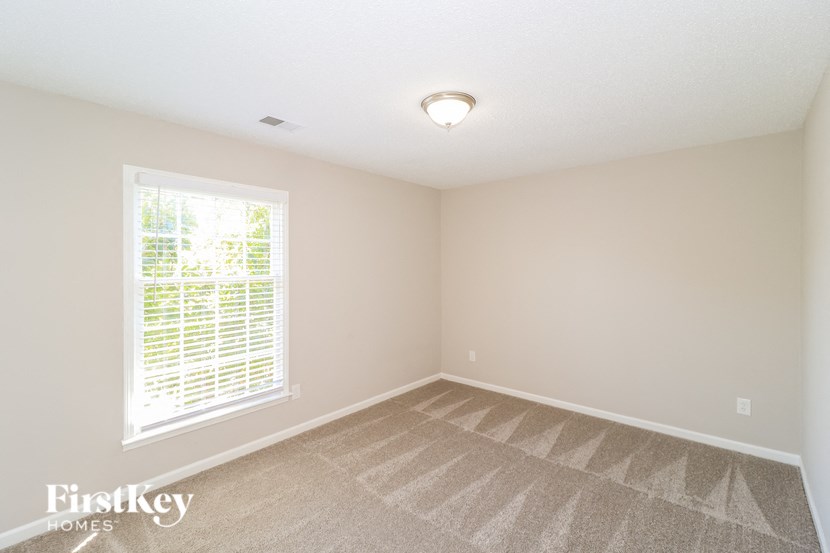 A room with a window and a carpet on the floor.