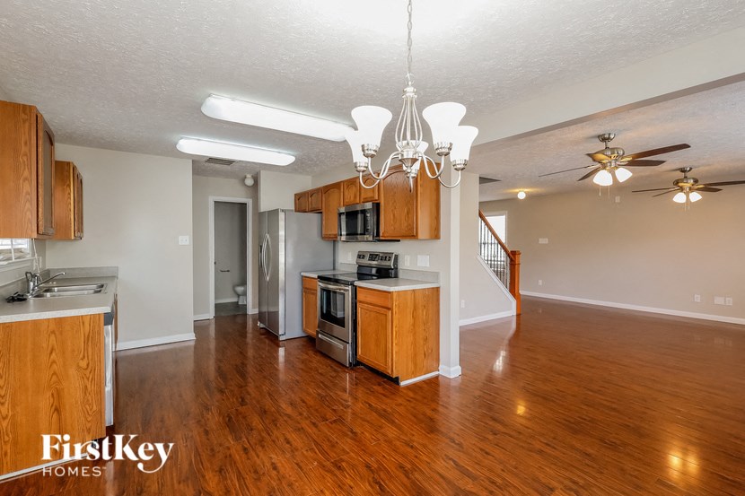 an empty kitchen and living room with wood flooring