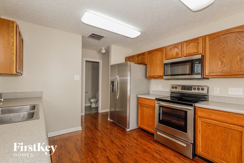a kitchen with wood flooring and stainless steel appliances